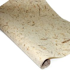 a rolled up piece of paper on top of a white surface with some brown spots