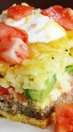 an omelet with tomatoes and other toppings on it sitting on a plate