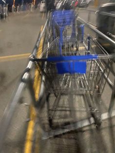 an empty shopping cart sitting on the side of a road