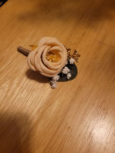 a wooden table topped with a flower and a small piece of wood on top of it