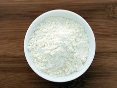 a bowl filled with white powder on top of a wooden table