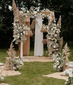 an outdoor wedding setup with white flowers and greenery