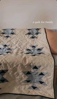 a quilt for family sitting on a couch with the cover pulled back to reveal it's design