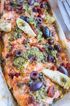 an entree with olives, capers and other toppings in a pan