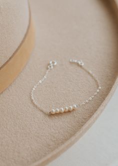 The bracelet version of our Pearl Linked Necklace. Let each of these pearls symbolize something special in your life. Use it as a daily reminder to count your blessing. 2-7 pearls are attached to our dainty cable chain. Bracelet is adjustable from 6.5 - 7". Available in 14kt Gold Fill + Sterling Silver. Layered with our Birdie Initial Bracelet. Handmade in Eau Claire, WI. Our jewelry is handmade so each piece will be unique and may vary slightly from what is pictured. Chain Bracelet With Beads, Handmade Chain Bracelet, Handmade Pearl Bracelets, Small Pearl Bracelet, Gelang Emas Aesthetic, Pearl Jwellary, Pearl Jewelry Aesthetic, Silver Beaded Jewelry, Silver Pearl Bracelet