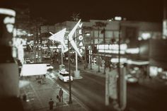 a black and white photo of a city street at night