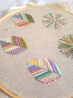 a close up of a embroidery on a piece of cloth with other items in the background