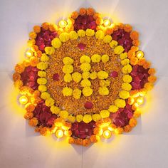 an arrangement of flowers and candles arranged in the shape of a circle