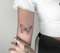 a woman's arm with a butterfly tattoo on the left side of her arm