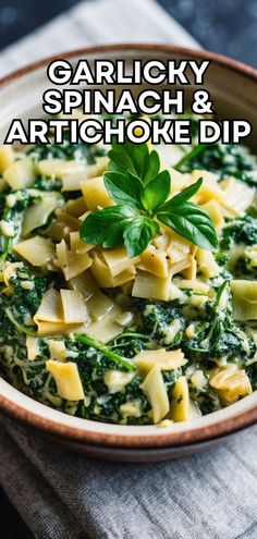 a bowl filled with spinach and artichoke dip on top of a table