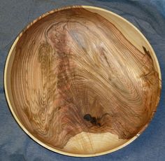 a wooden bowl sitting on top of a blue cloth