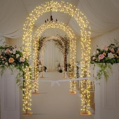 an archway decorated with lights and flowers