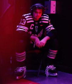 a man sitting on top of a chair next to a fire hydrant in a dark room