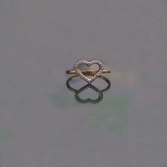 a heart shaped diamond ring sitting on top of a table