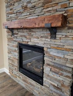 a stone fireplace with a wooden mantle and shelf