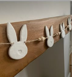 some bunny ears are hanging on a wooden board with string attached to the top and bottom