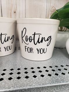 two white cups with black writing on them