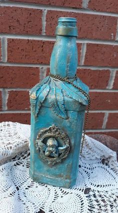 a blue bottle sitting on top of a white doily next to a brick wall