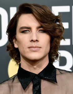 a close up of a person wearing a black shirt and tie with his hair pulled back