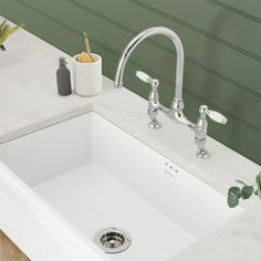 a white kitchen sink sitting under a faucet