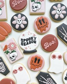 many decorated cookies are arranged on a table top with the words spooky season spelled in black and white