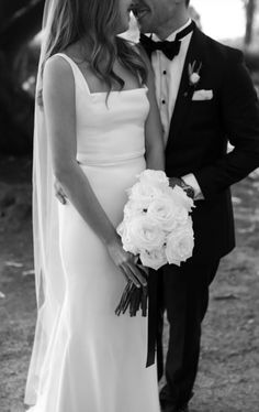 a bride and groom kissing each other in black and white