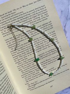 an open book with a necklace on top of it