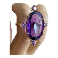 Stunning  18 kt yellow gold Large Amethyst Ring 4 mm 1/2 round shanking with wire gallery. center prong set with fine oval amethyst 28.5 x 20.5 x 13.5 mm approximately 43.10 carats Accented with 4 prong set lighter colored 5mm round amethyst. Approximate gold weight = 5.3 dwt or 8.24 grams. 1.5" D by 1.25"w by 1.25" h  thanks Purple Amethyst Oval Cabochon Ring, Oval Purple Amethyst Ring For Formal Occasions, Oval Purple Amethyst Ring With Center Stone, Luxury Purple Amethyst Oval Cabochon Ring, Oval Purple Amethyst Ring With Gemstone Accents, Oval Purple Amethyst Ring, Oval Amethyst Ring In Luxury Style, Oval Amethyst Ring In Yellow Gold, Oval Amethyst Multi-stone Ring In Yellow Gold