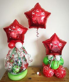 three red balloons with santa's sleigh and reindeers in them on a table