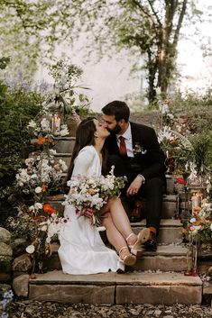 a bride and groom kissing on the steps outside