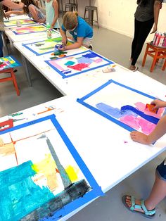 children are painting on large canvass in an art class