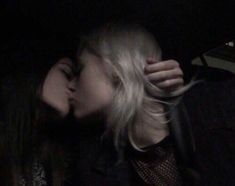 two people are kissing in the dark, one is holding an umbrella and the other has her hand on her head