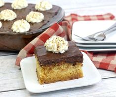 a piece of cake sitting on top of a white plate next to a red and white checkered napkin