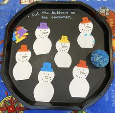 a tray with snowmen cut out on it and some magnets in the middle