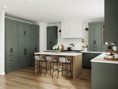 a large kitchen with green cabinets and white counter tops, along with bar stools