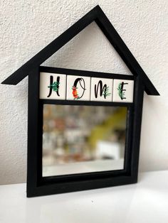 a house shaped mirror sitting on top of a table