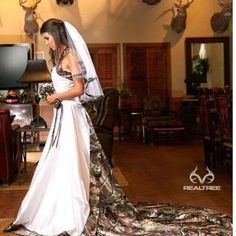 a woman in a wedding dress standing on the floor with deer antlers behind her