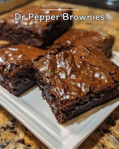 three brownies on a plate with chocolate frosting