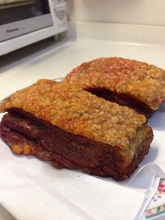 two pieces of food sitting on top of a paper towel next to a toaster oven