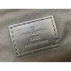 a label on the back of a gray jacket with black stitching and leather trim