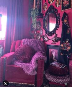 a living room with pink walls and pictures on the wall, purple chair and mirror