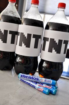 three soda bottles sitting on top of a counter next to toothpaste and candy