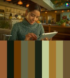 a woman is looking at her tablet while sitting in front of the camera with color swatches