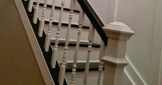 the stairs are painted white and have black balusters on them, along with an iron hand rail