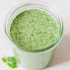 a green smoothie in a mason jar with cilantro sprinkled on top