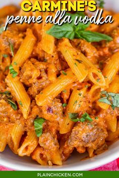 a white bowl filled with pasta and meat covered in sauce, garnished with parsley