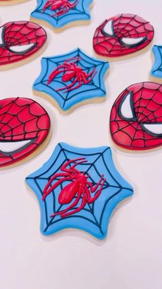 spiderman cookies decorated with royal icing on a white table top, ready to be eaten