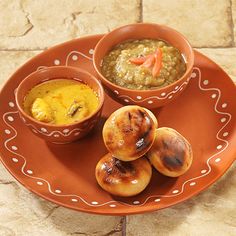 an orange plate topped with different types of food on top of a tile flooring