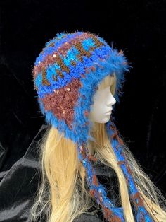 a mannequin head wearing a knitted hat with blue, brown and white yarn