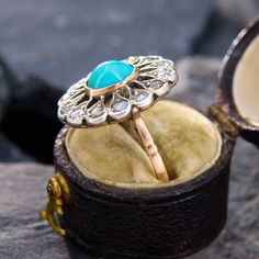 This alluring ring features an oval cabochon cut turquoise that is bezel set.  The turquoise is accented with a rose cut diamond halo in sterling silver with milgrain edging. The ring is crafted in 10k rosy yellow gold, and is currently a size 7.  The ring has been previouly sized. Diamond Halo, Rose Cut Diamond, Oval Cabochon, A Rose, Yellow Gold Rings, Bezel Setting, Halo Diamond, Rose Cut, Turquoise Ring